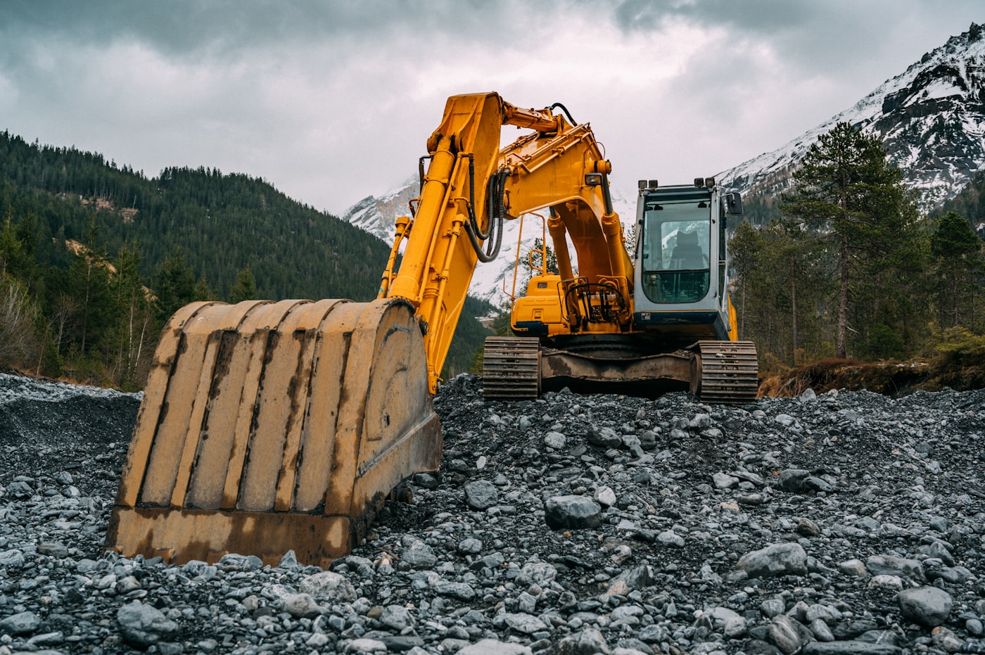 A yellow excavator of the kind hauled on heavy-equipment trailers